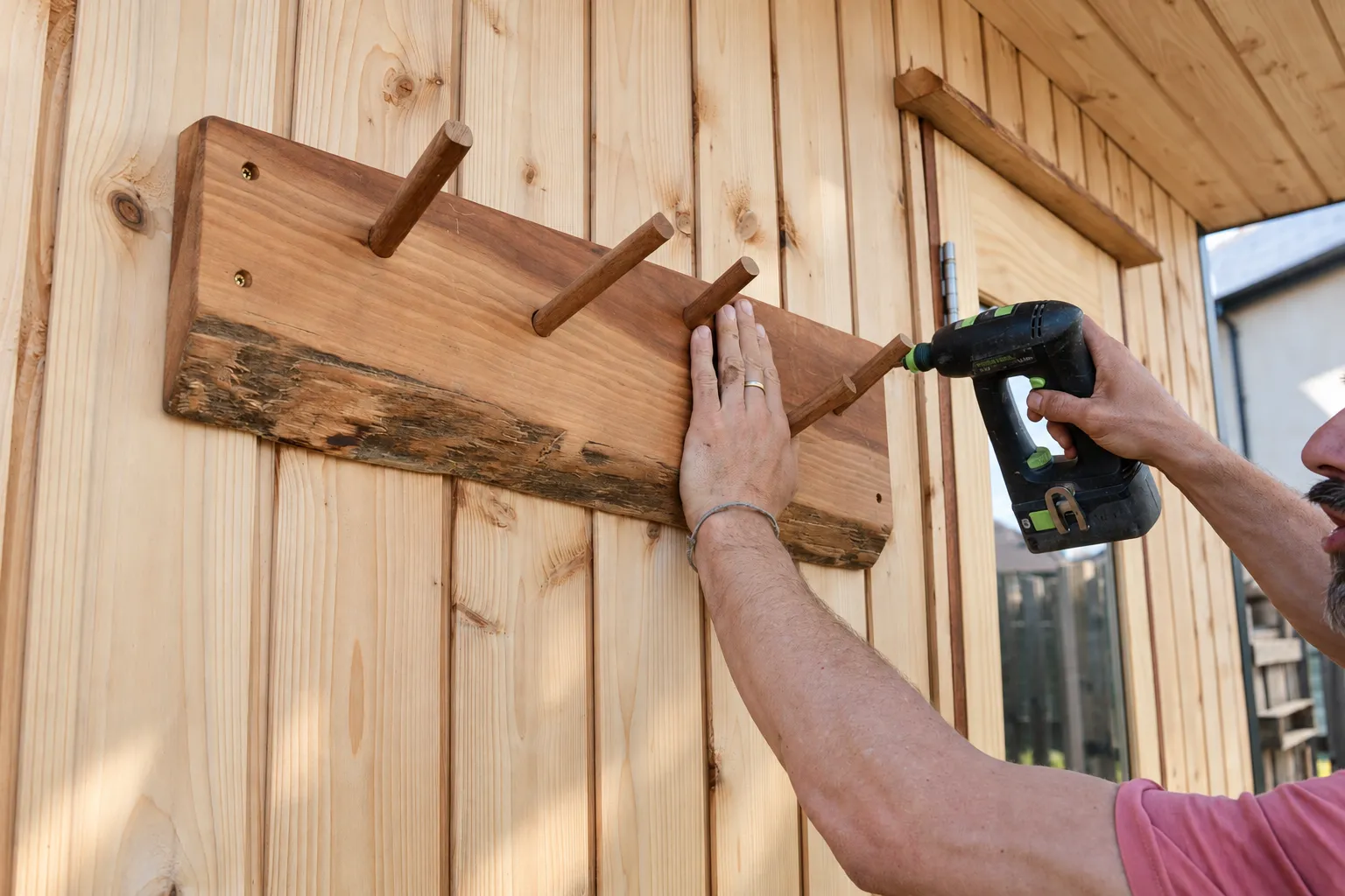 Dan fitting wooden pegs to a live-edge timber rail